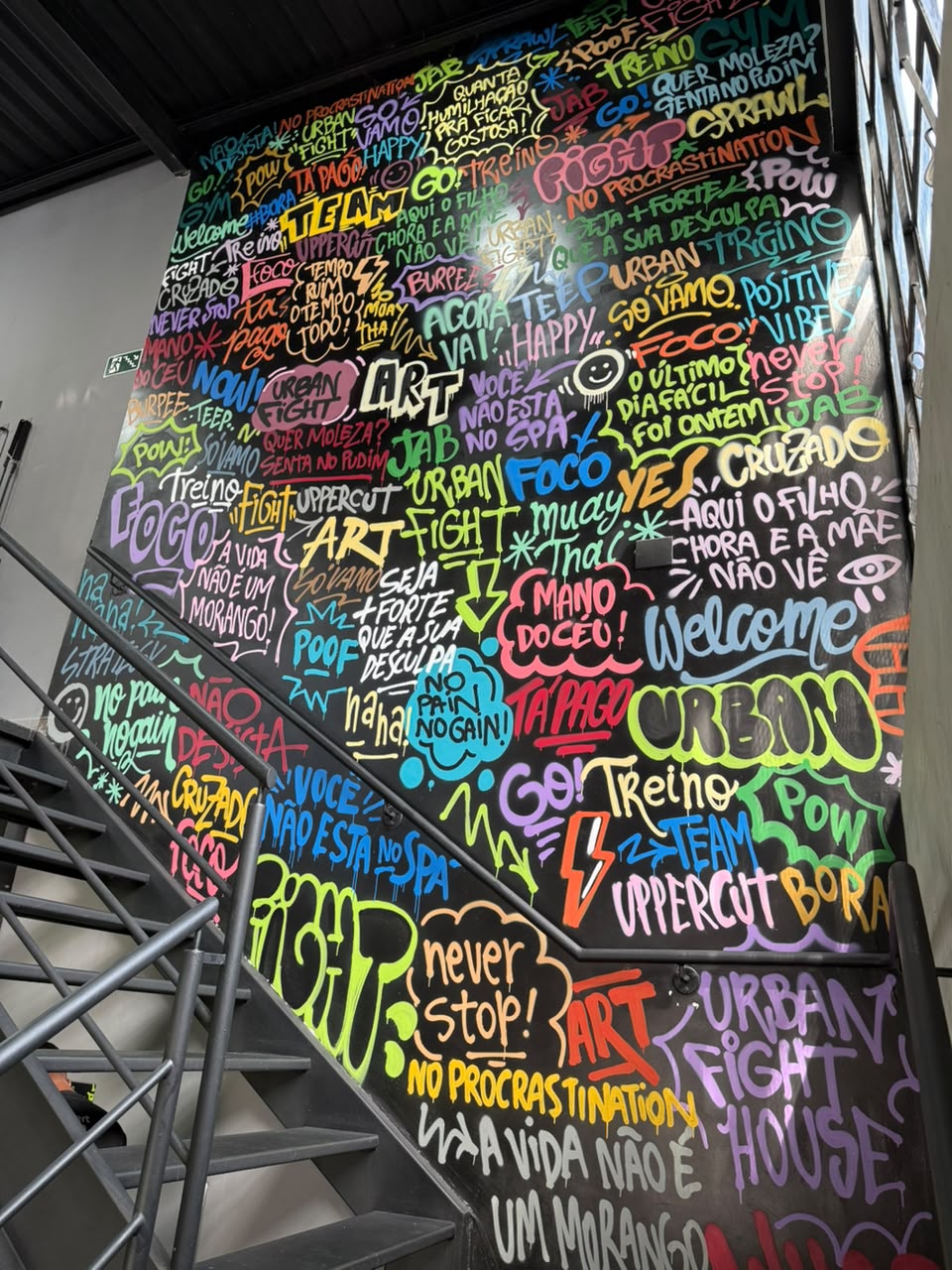 Sala superior de boxe da Vila Olímpia com sacos de pancada e parede grafitada colorida