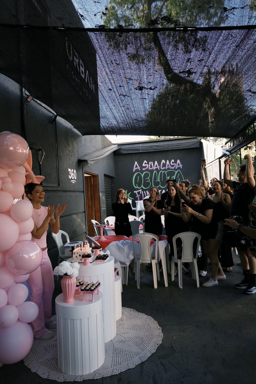 Galera comemorando aniversário no deck da Urban com bolo e balões