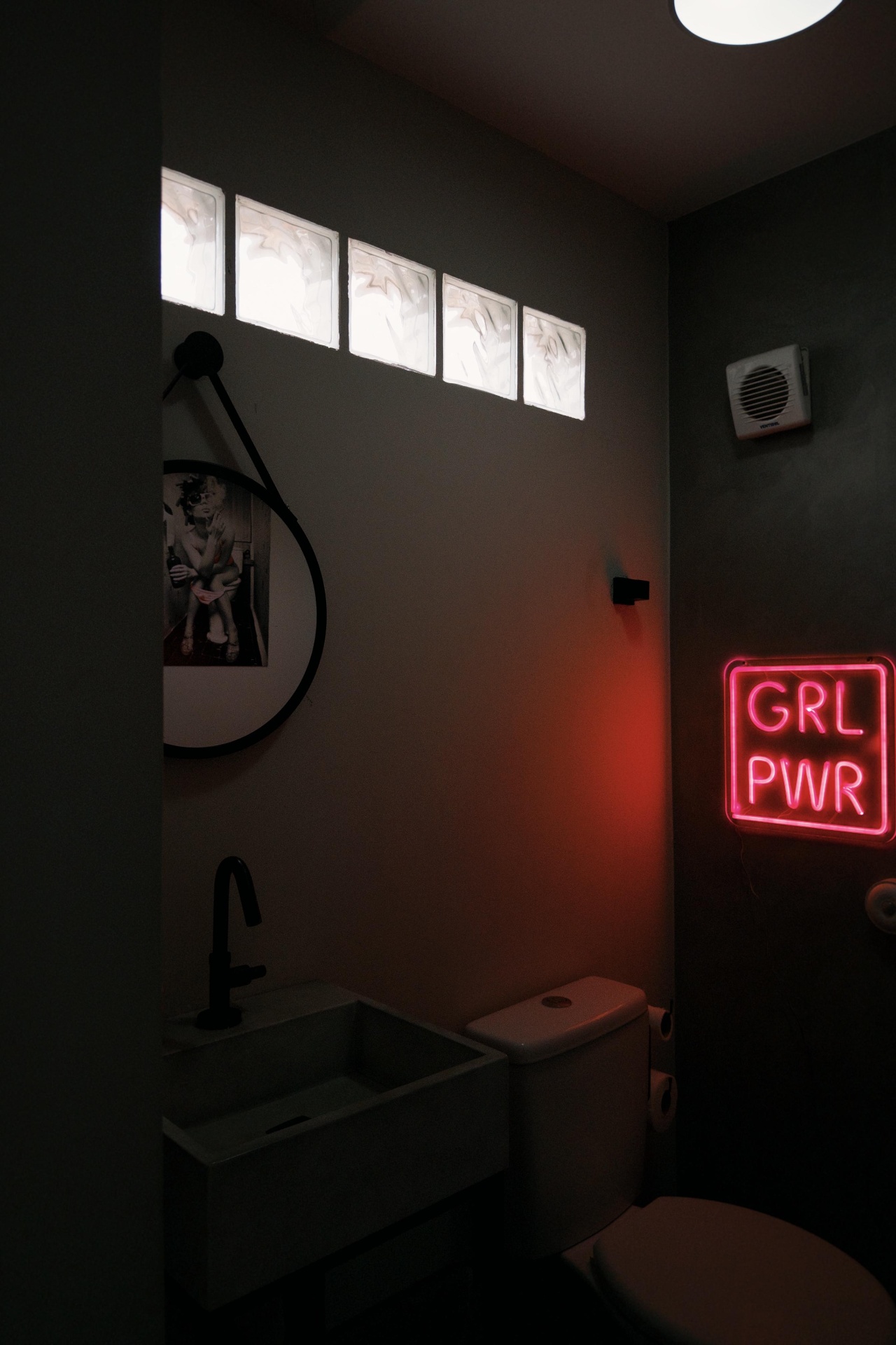 Sala de sacos de pancada com parede grafitada e letreiro neon Urban Fight House