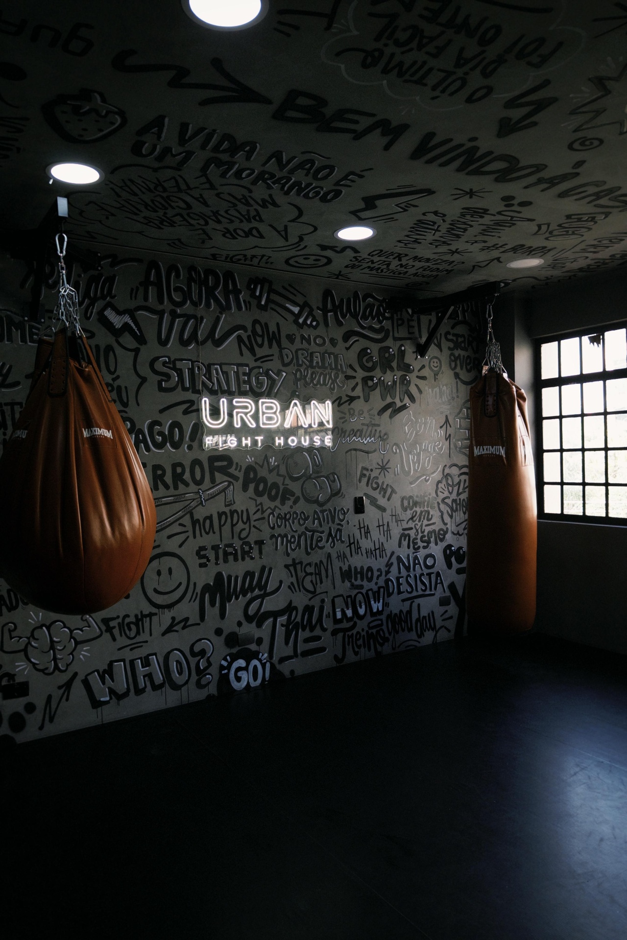 Grafite Urban Fight House com luvas de boxe na escada da unidade Vila Madalena